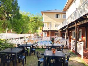 un grupo de mesas y sillas junto a un edificio en Valeria Costa y Mar, en Valeria del Mar