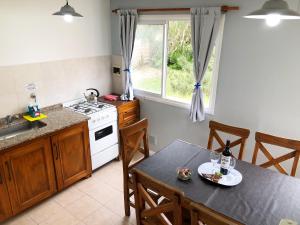 una cocina con una mesa y una estufa horno superior en Valeria Costa y Mar, en Valeria del Mar