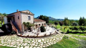 a house with a large stone patio in front of it at AGRITURISMO iL PIOPPETO in Cassino