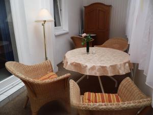 una mesa con sillas y un jarrón con una flor. en Apartments Haus Eintracht Sellin, en Ostseebad Sellin