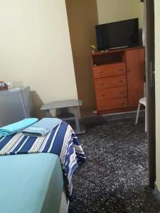 1 dormitorio con 1 cama, vestidor y TV en Nueva Alborada Lodging House en Fernando de la Mora
