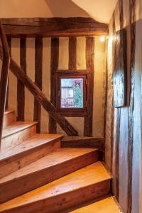 Cette chambre dispose d'un escalier en bois et d'une fenêtre. dans l'établissement La Venelle Saint Jean, à Honfleur
