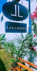 un signe pour un signe à la lobrote à côté d'un banc dans l'établissement Hotel Las Liebres, à Villaguay