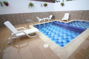 una piscina con 2 sillas y una mesa en Casa El Mangle, en Cartagena de Indias