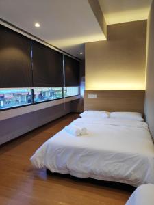 1 dormitorio con 2 camas y ventana grande en EZ Suites en Bandar Seri Begawan