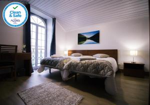 a bedroom with a bed and a sign that says clean and safe at Cantinho do Pensamento in Ribeira Grande