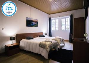 um quarto com uma cama e uma placa que diz limpo e seguro em Cantinho do Pensamento na Ribeira Grande