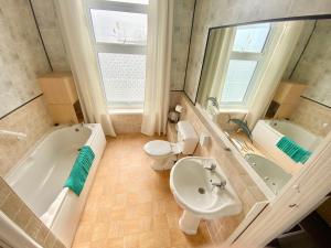 a bathroom with a tub and a toilet and a sink at Oceana Holiday Apartments in Bridlington +129 photos