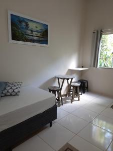 a bedroom with a bed and a table and chairs at Flats Jordão in Abraão