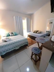 a bedroom with a bed and two stools in it at Flats Jordão in Abraão