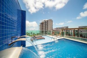 a swimming pool on top of a building at Tambaqui Praia Hotel in Maceió