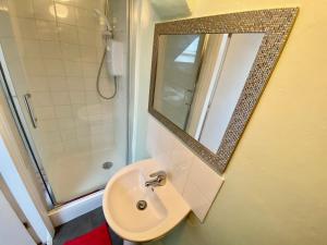 a bathroom with a sink and a shower and a mirror at Oceana Holiday Apartments in Bridlington