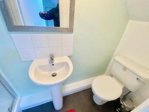 a bathroom with a sink and a toilet and a mirror at Oceana Holiday Apartments in Bridlington