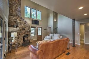 uma sala de estar com um sofá e uma lareira de pedra em Beaver Lake Hideaway with Fire Pit by Marina em Springdale