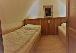 Kleines Zimmer mit einem Bett und einem Fenster in der Unterkunft Mäcky Baude in Dippoldiswalde
