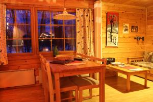 a wooden dining room with a table and a window at Ounasloma Luxury Cottages in Enontekiö