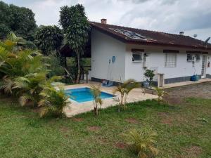 ein Haus mit einem Swimmingpool davor in der Unterkunft Pousada e Marina Pier 44 in Nazaré Paulista