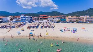 a group of people in the water at a beach at House Kostas on the beach in Sarti