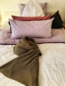 a pile of pillows and a blanket on a bed at Citylodge R53 in Stuttgart