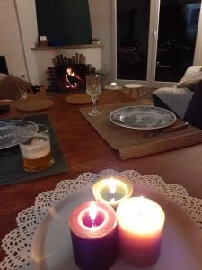 a table with two candles and a glass of beer at un ptit chalet in Les Brenets