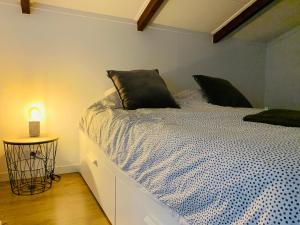 a bedroom with a bed with a black pillow on it at Beach House Parallel in Noordwijk