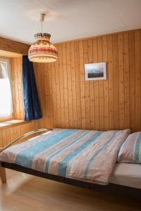 1 dormitorio con cama y lámpara de araña en Casa Curgnun 21 Collenberg - Ferienwohnung 61m2 für max. 4 Pers. en Morissen