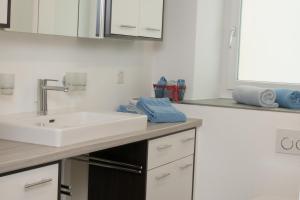 a kitchen with a sink and a counter with blue towels at Casa Curgnun 21 Collenberg - Ferienwohnung 61m2 für max. 4 Pers. in Morissen