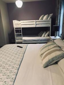 a bedroom with a white bunk bed with pillows at White Horse Farm Inn in Pickering