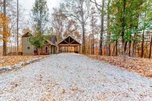 ein Haus im Wald mit einer Kiesauffahrt in der Unterkunft Bearfoot Lodge in Ellijay