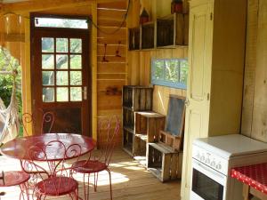 patio con mesa, sillas y fogones en La Roulotte de la Fay, en Dompierre-les-Ormes