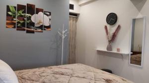 a bedroom with a clock and paintings on the wall at MOTEL KATERINA in Keratea