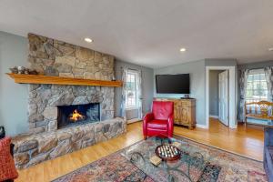 a living room with a stone fireplace and a red chair at Martin Grandview Estate in Lancaster