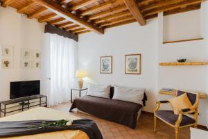 Un dormitorio con una cama, un televisor y una silla. en Relais Rasella 47, en Roma