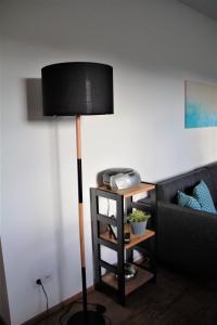 lámpara de pie en la sala de estar con sofá en Ferienwohnung Heideblick, en Volkesfeld