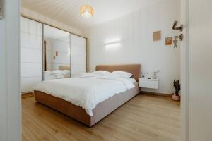 ein Schlafzimmer mit einem großen Bett und einem großen Spiegel in der Unterkunft Oasis Residence in Baia Mare