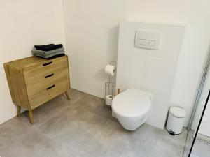 a bathroom with a toilet and a wooden dresser at Beach House Parallel in Noordwijk +22 photos