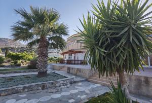 two palm trees in front of a house at Vlycha Beach Apartments in Lindos