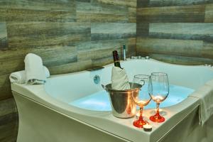 a bath tub with two wine glasses and a bucket at Hotel La Esperanza in Cartagena de Indias