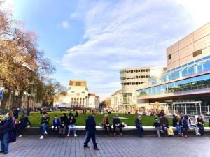 a group of people sitting on a bench in front of a building at Andefu Hotel am Kantpark in Duisburg