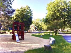 a playground with a red phone booth in a park at Andefu Hotel am Kantpark in Duisburg