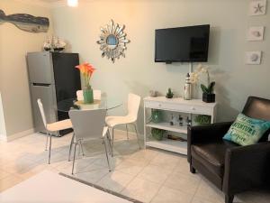 un soggiorno con tavolo e TV di Dockside Daze! a Galveston