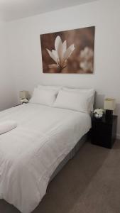 ein Schlafzimmer mit einem weißen Bett und einem Gemälde an der Wand in der Unterkunft Belvedere Suites in Belvedere