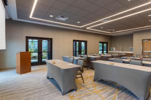 a conference room with tables and chairs and a podium at Wyndham Garden Orlando Universal / I Drive in Orlando