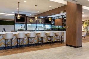a bar in a hotel lobby with stools at Wyndham Garden Orlando Universal / I Drive in Orlando