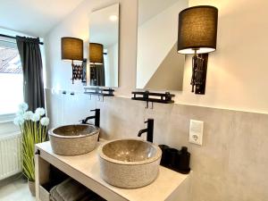 La salle de bains est pourvue de 2 lavabos et de 2 miroirs. dans l'établissement Schöne Ferienwohnungen teilweise mit Dachterrasse im Herzen von Itzehoe, à Itzehoe