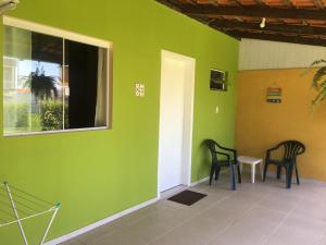 Habitación con paredes verdes, 2 sillas y ventana en Refúgio do Bosque, en Penha
