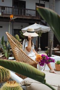 a woman sitting in a chair wearing a straw hat at Hotel Boutique Palacio Ico in Teguise