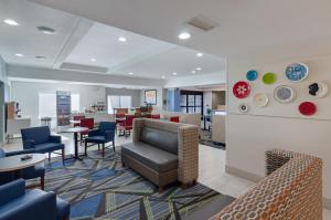 um átrio com uma sala de espera com cadeiras e mesas em Holiday Inn Express Hotel & Suites Weston, an IHG Hotel em Weston