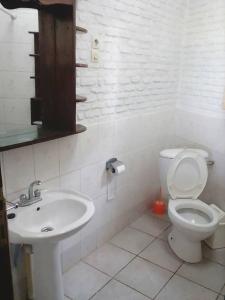 a white bathroom with a toilet and a sink at VAYA APARTMENTS Kiriri with Panoramic View in Bujumbura