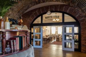 a room with a brick wall and a book shelf with books at The Holbrooke Hotel in Grass Valley